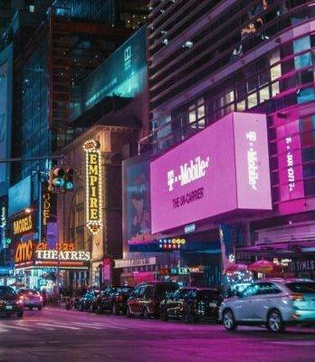 Times Square lit up at night, showing many brands off